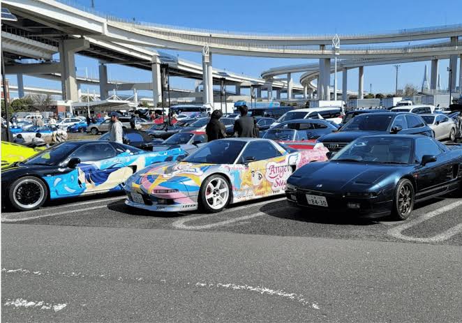 Daytime car meet at Daikoku PA with Honda NSX lineup under the expressway loops
